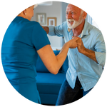 An elderly man dances with his care worker
